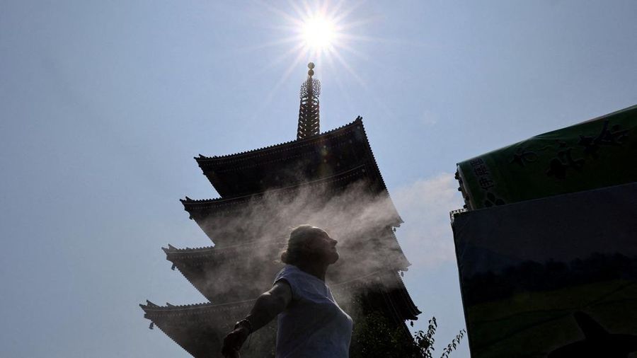 Seorang visitor beristirahat di dekat kabut pendingin di depan pagoda lima lantai di kuil Sensoji, lokasi wisata populer, saat pemerintah Jepang mengeluarkan peringatan serangan panas di Tokyo dan prefektur lainnya lantaran gelombang panas, di Tokyo