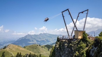 This aerial photograph shows tourists enjoying the new BalancAIR, a giant swing at the top of the Grand Chamossaire peak, above Villars-sur-Ollon, western Switzerland, on July 20, 2026. Inaugurated at the beginning of the month, the Grand Chamossaire