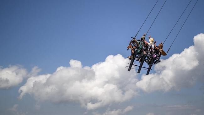 This photograph shows tourists enjoying the new BalancAIR, a giant swing at the top of the Grand Chamossaire peak, above Villars-sur-Ollon, western Switzerland, on July 20, 2026. Inaugurated at the beginning of the month, the Grand Chamossaire swing