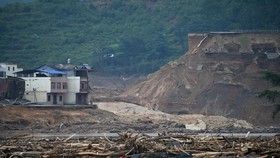 A collapsed section of the Liulan reservoir is pictured in Liulan village in Hengzhou city, Chinas southwest Guangxi region, on July 8, 2026. Rescuers scoured flooded parts of China for survivors on July 8 after storms killed 17 people and caused doz