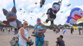 Wisatawan mancanegara mengunjungi acara layangan internasional pada Rare Angon Festival 2026 di Pantai Mertasari, Sanur, Denpasar, Kamis (23/7/2026). Festival tahunan yang digelar pada 23-26 Juli 2026 tersebut diikuti peserta dari 23 negara dengan me