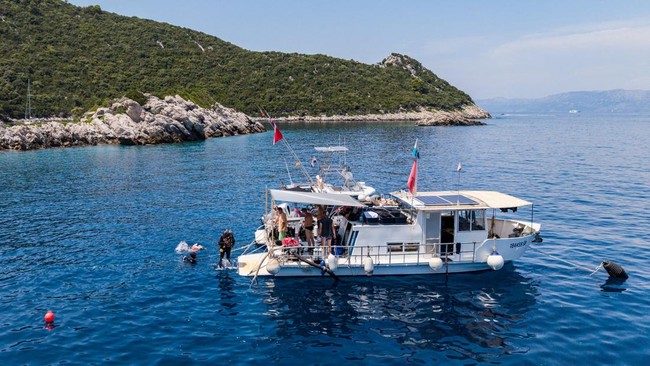 Sebuah rekaman dari drone memperlihatkan seorang arkeolog bawah air melompat dari sebuah kapal menuju lokasi penemuan bangkai kapal Bizantium di dekat Polace, Pulau Mljet, Kroasia, pada 20 Juli 2026. REUTERS/Antonio Bronic