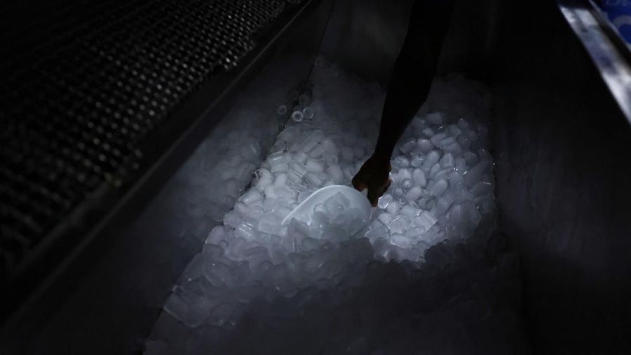 Karyawan Blue Ice, Evans Osagie, memasukkan es batu ke dalam kantong di akomodasi perusahaan selama gelombang panas di Athena, Yunani, 22 Juli 2026.