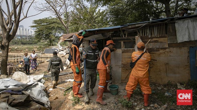 Petugas merobohkan bangunan semi permanen dalam penertiban bangunan liar dan lapak PKL di sepanjang bantaran Kanal Banjir Barat (BKB), Tanah Abang.