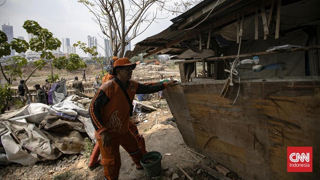 Petugas merobohkan bangunan semi permanen dalam penertiban bangunan liar dan lapak PKL di sepanjang bantaran Kanal Banjir Barat (BKB), Tanah Abang.