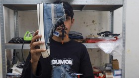 Perajin Bunay Ilhamullah menunjukan sepatu berbahan limbah kain jeans di rumah produksi Bumoe, Banda Aceh, Aceh.