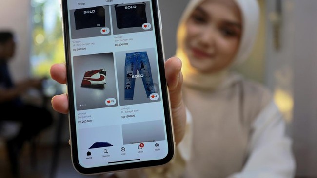 Calon pembeli memperlihatkan produk fesyen berbahan limbah jeans pada platform e-commerce di Banda Aceh, Aceh.