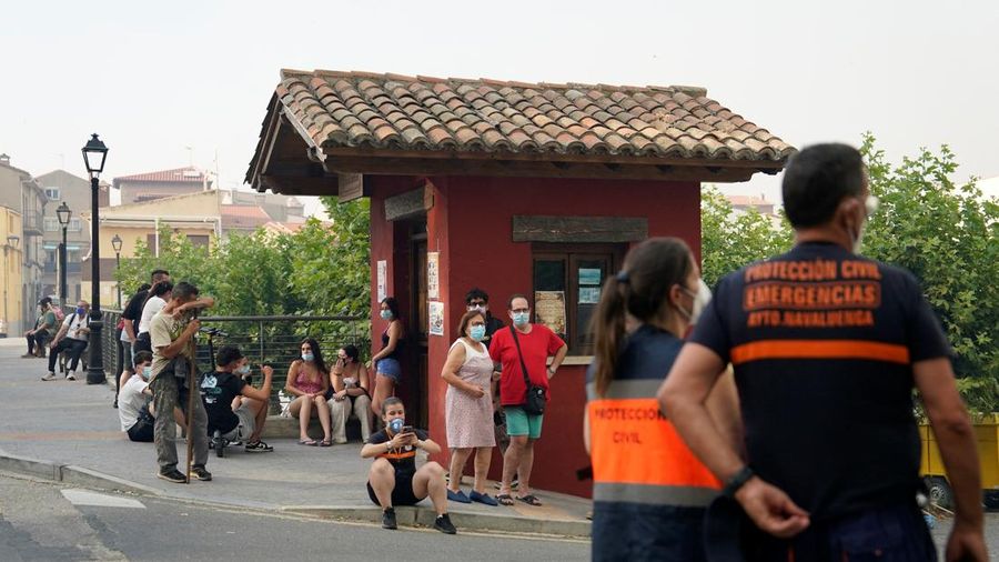 Orang-orang menyaksikan kebakaran rimba dari seberang sungai Alberche di Navaluenga, Avila, Spanyol, 23 Juli 2026.