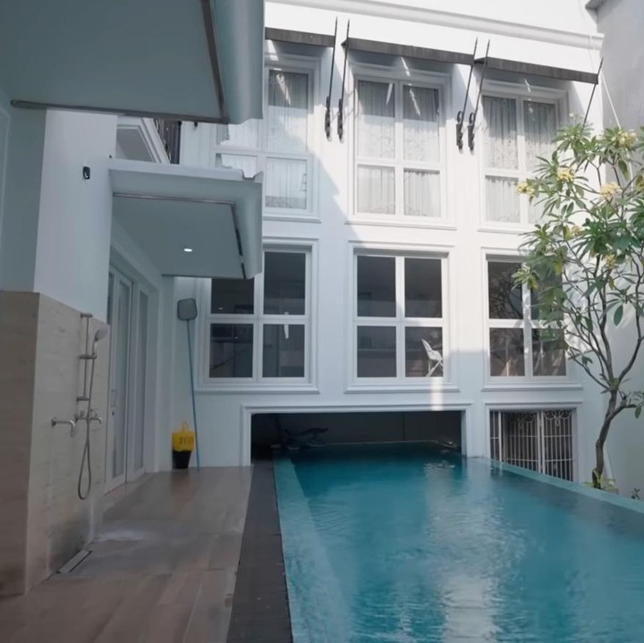 <p>Rumah ini juga dilengkapi dengan kolam renang pribadi. Bentuk kolam renang memanjang yang berada di area semi outdoor. Dinding berwarna putih dipadukan dengan tanaman kamboja menciptakan suasana tenang dan segar. (Foto: YouTube Thariq Halilintar)</p>