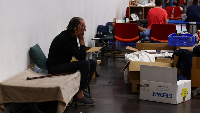FILE PHOTO: An evacuee waits on a camp bed at the Bordeaux-Lac Exhibition Centre, which has been turned into a shelter for people displaced by a wildfire burning nearby amid worsening drought conditions following a heatwave and water shortages across