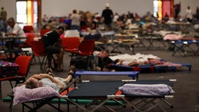 FILE PHOTO: A man rests at the Bordeaux-Lac Exhibition Centre, which has been turned into a shelter for people displaced by a wildfire burning nearby amid worsening drought conditions following a heatwave and water shortages across much of France, in