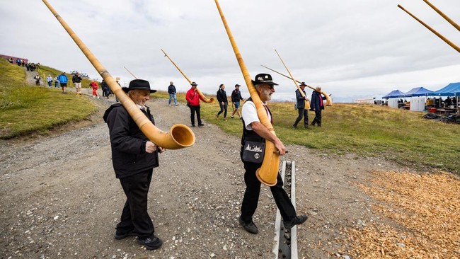 Alphorn blowers carry their instrument on the last day of the International Alphorn Festival on the alpine pasture of Tracouet in Nendaz, in southern Switzerland, July 26, 2026. REUTERS/Pierre Albouy
