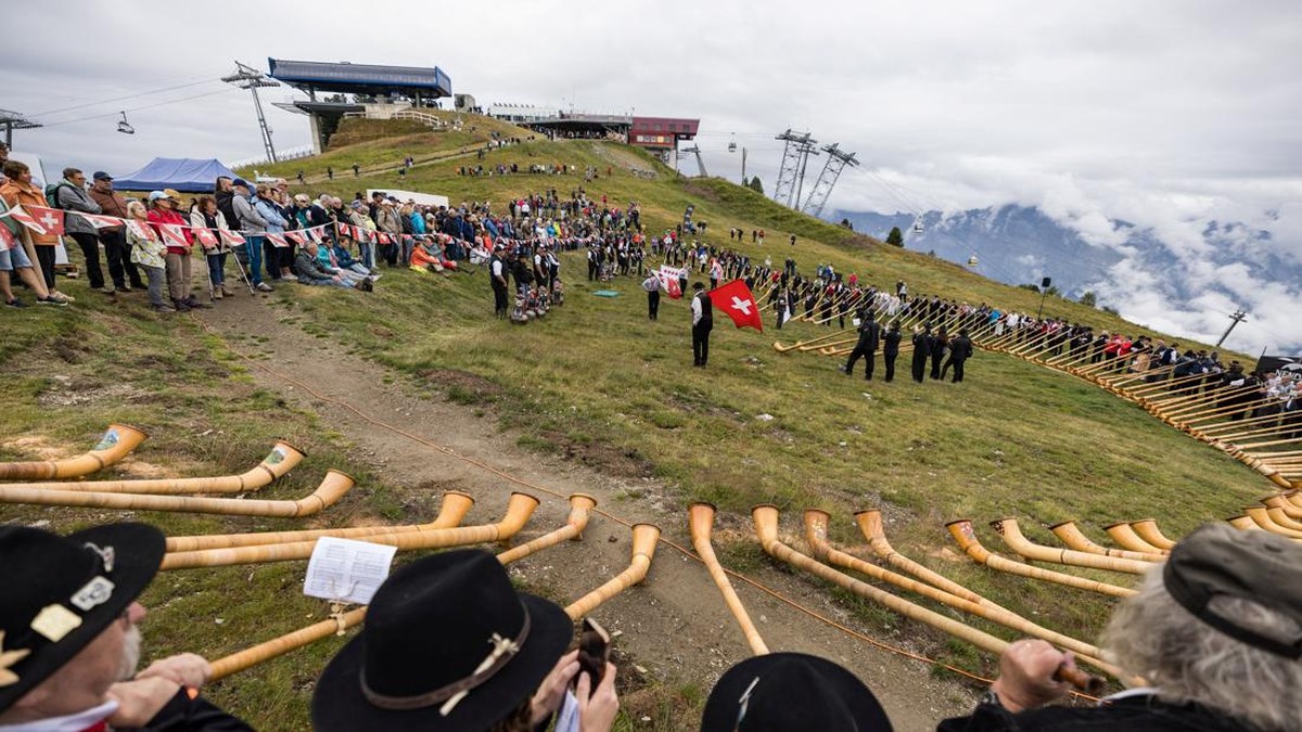 Alphorn blowers and flag throwers perform an ensemble piece on the last day of the International Alphorn Festival on the alpine pasture of Tracouet in Nendaz, in southern Switzerland, July 26, 2026. REUTERS/Pierre Albouy