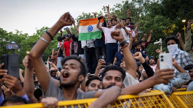 Supporters of India's Cockroach Janta Party (CJP) celebrate after India's Education Minister Dharmendra Pradhan resigned following days of protests demanding his resignation over National Eligibility cum Entrance Test (NEET) examination paper leaks,