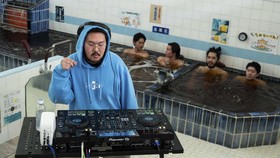 DJ Zendo performs a set as part of the Login.jp project as people bathe at the Electric Water Heater sauna in Sumida, Tokyo on April 12, 2026. The collective, Login.jp, moves from shoot to shoot across the archipelago: from a dye workshop and a tofu