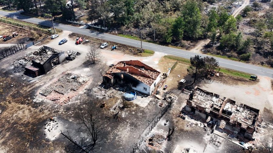 Foto udara menunjukkan rumah nan terbakar di wilayah nan terkena akibat kebakaran hutan, di Le Porge, Gironde, di tengah kondisi kekeringan nan memburuk setelah gelombang panas dan kekurangan air di sebagian besar wilayah Prancis, Minggu (26/7/2026). (REUTERS/Manon Cruz)