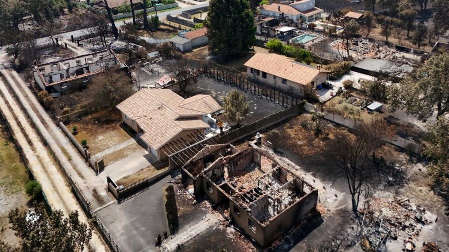 Foto udara menunjukkan rumah nan terbakar di wilayah nan terkena akibat kebakaran hutan, di Le Porge, Gironde, di tengah kondisi kekeringan nan memburuk setelah gelombang panas dan kekurangan air di sebagian besar wilayah Prancis, Minggu (26/7/2026). (REUTERS/Manon Cruz)