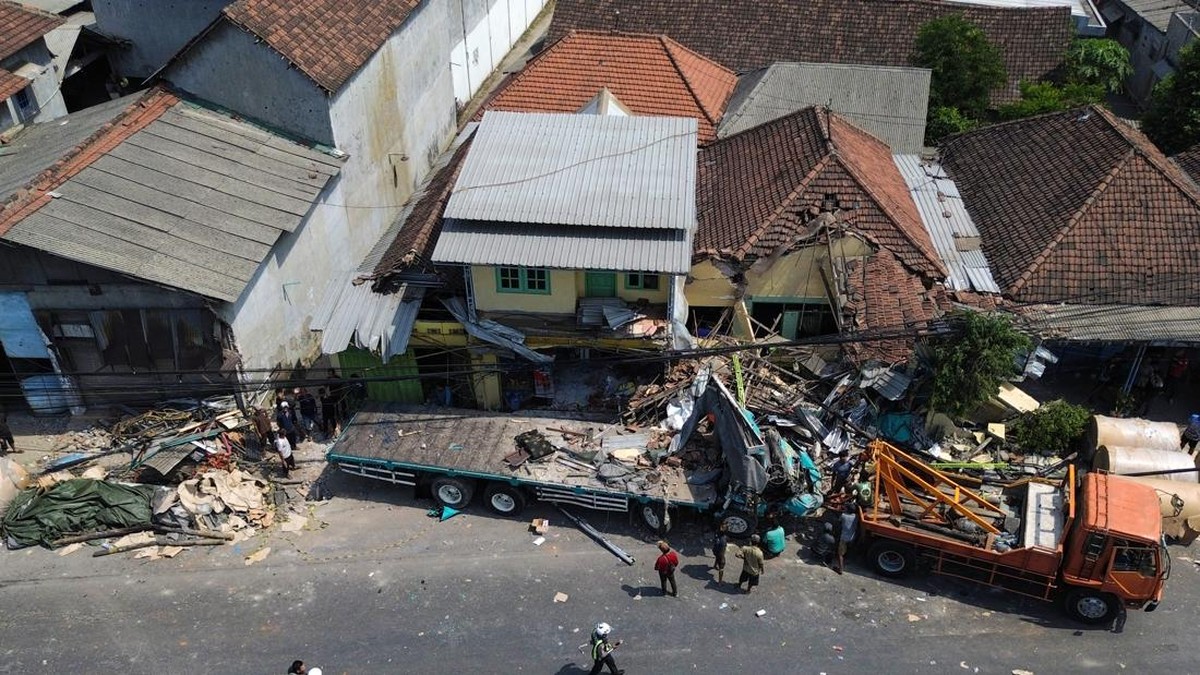 Warga melihat proses evakuasi truk yang mengalami kecelakaan di Jalan Nasional Surabaya-Malang, Dusun Mojorejo, Desa Ngerong, Kecamatan Gempol, Kabupaten Pasuruan, Jawa Timur, Senin (27/7/2026). Kecelakaan yang terjadi sekitar pukul 06.15 tersebut me