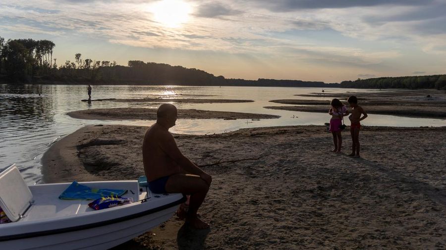 Orang-orang menikmati hari musim panas nan terik di tepian pasir nan baru muncul di Sungai Danube saat permukaan air menurun selama cuaca panas berkepanjangan dan kondisi kering, di Apatin, Serbia, 26 Juli 2026.
