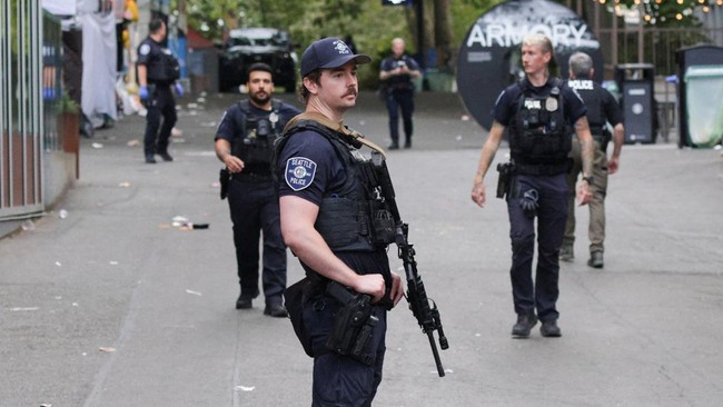 Police officers stand guard at a site after Seattle Police responded to what they described as a shooting with