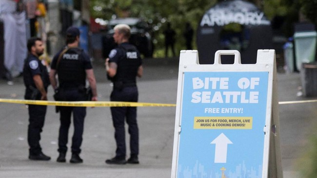Police officers stand guard at a site after Seattle Police responded to what they described as a shooting with
