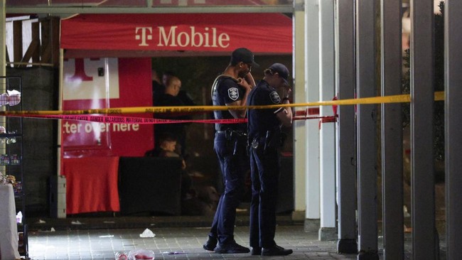 Police officers stand at a cordoned-off area after Seattle Police responded to what they described as a shooting with