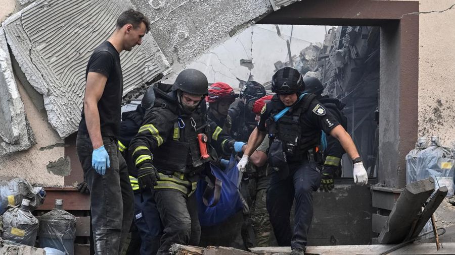 Tim penyelamat dan petugas polisi membawa jenazah seorang penduduk nan tewas di letak perusahaan penyedia air minum nan terkena serangan udara Rusia, di tengah serangan Rusia terhadap Ukraina, di Zaporizhzhia, Ukraina, 25 Juli 2026.