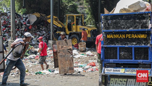 Sejumlah petugas kebersihan mengantarkan sampah ke Tempat Penampungan Sementara (TPS) Rawajati Barat, Jakarta Selatan, Jumat (27/7). (CNN Indonesia/Febria Adha L)