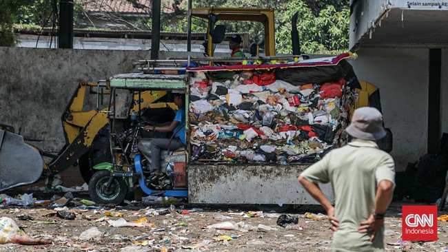 Sejumlah petugas kebersihan mengantarkan sampah ke Tempat Penampungan Sementara (TPS) Rawajati Barat, Jakarta Selatan, Jumat (27/7). (CNN Indonesia/Febria Adha L)