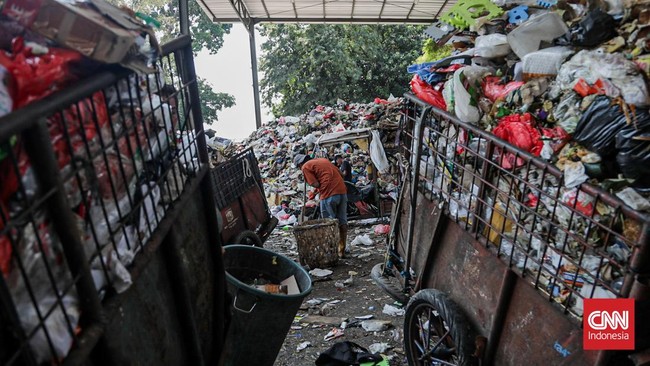 Sejumlah petugas kebersihan mengantarkan sampah ke Tempat Penampungan Sementara (TPS) Rawajati Barat, Jakarta Selatan, Jumat (27/7). (CNN Indonesia/Febria Adha L)