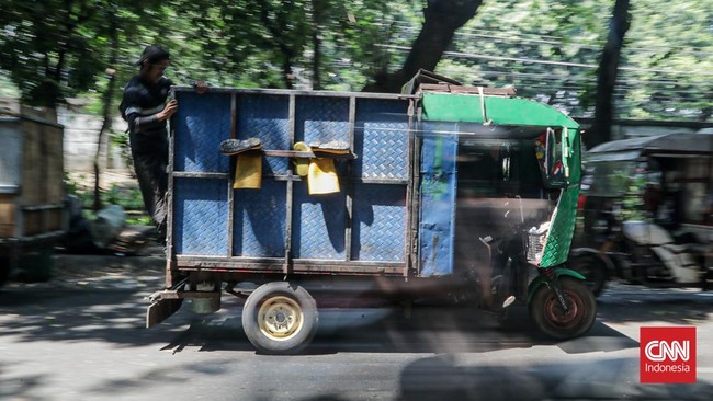 Sejumlah petugas kebersihan mengantarkan sampah ke Tempat Penampungan Sementara (TPS) Rawajati Barat, Jakarta Selatan, Jumat (27/7). (CNN Indonesia/Febria Adha L)