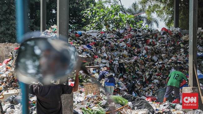Sejumlah petugas kebersihan mengantarkan sampah ke Tempat Penampungan Sementara (TPS) Rawajati Barat, Jakarta Selatan, Jumat (27/7). (CNN Indonesia/Febria Adha L)