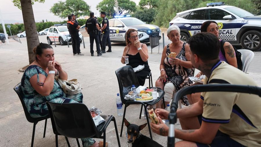 Warga dari desa-desa nan dievakuasi duduk untuk makan di pusat olahraga nan digunakan untuk menampung pengungsi, di Moncofa, Castellon, Spanyol, 26 Juli 2026.