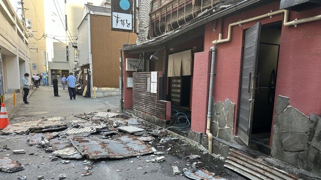 The exterior wall of a shop is seen collapsed in an earthquake, in Kumamoto City on July 28, 2026. (Photo by JIJI Press / AFP) / Japan OUT