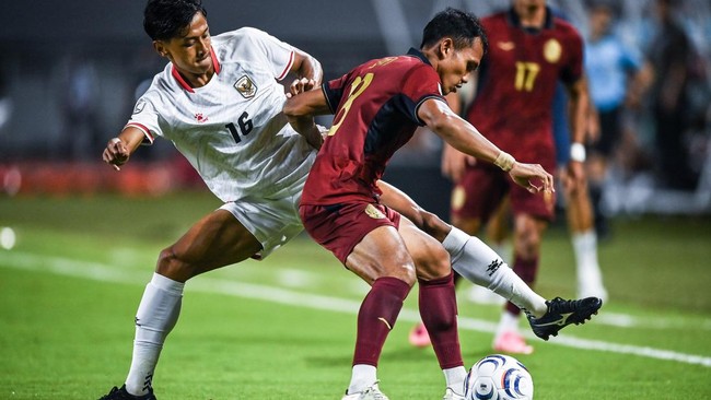 Pesepak bola Timnas Indonesia Dony Tri Pamungkas (kiri) berebut bola dengan pesepak bola Timnas Kamboja RSovann Ouk (kanan) pada pertandingan Grup A ASEAN Championship atau Piala AFF 2026 di Stadion Gelora Pakansari, Kabupaten Bogor, Jawa Barat, Seni