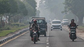 Pengendara melintas di Jalan Adonis Samad yang diselimuti asap di Palangka Raya, Kalimantan Tengah, Selasa (28/7/2026). Kabut asap yang menyelimuti Kota Palangka Raya tersebut merupakan dampak dari kebakaran hutan dan lahan yang mengakibatkan burukny