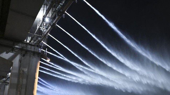 People watch the Moonlight Rainbow Fountain on Banpo Bridge, over the Han River in Seoul on July 28, 2026. (Photo by GREG BAKER / AFP)