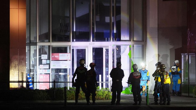 Police stand at the entrance to the Aeon Mall Kumamoto, which was damaged after an earthquake, in Kashima on July 28, 2026. Dozens of people were feared trapped in the shopping mall in Japan on July 28 after a major earthquake toppled buildings, spar