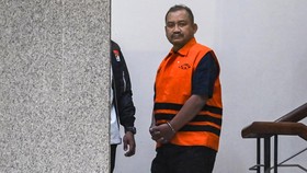 Bupati Pemalang Anom Widiyantoro (kanan) berjalan keluar gedung usai menjalani pemeriksaan di Gedung Merah Putih KPK, Jakarta, Kamis (30/7/2026).