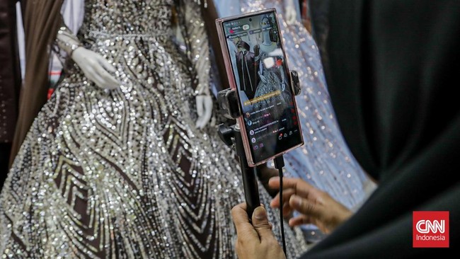Seorang pedagang mempromosikan dagangannya di salah satu kios Pusat Grosir Tekstil Tanah Abang, Jakarta, Kamis (30/7). (CNN Indonesia/Febria Adha L).