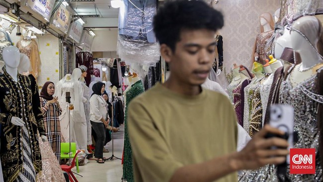 Seorang pedagang mempromosikan dagangannya di salah satu kios Pusat Grosir Tekstil Tanah Abang, Jakarta, Kamis (30/7). (CNN Indonesia/Febria Adha L).