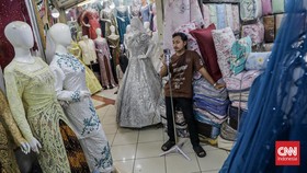 Seorang pedagang mempromosikan dagangannya di salah satu kios Pusat Grosir Tekstil Tanah Abang, Jakarta, Kamis (30/7). (CNN Indonesia/Febria Adha L).