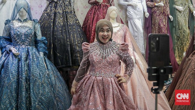 Seorang pedagang mempromosikan dagangannya di salah satu kios Pusat Grosir Tekstil Tanah Abang, Jakarta, Kamis (30/7). (CNN Indonesia/Febria Adha L).