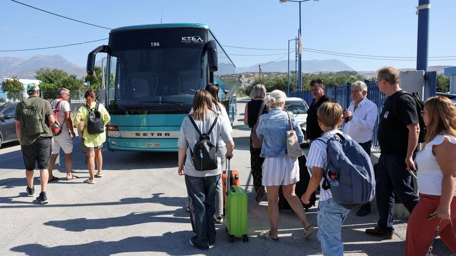 Para visitor bersiap untuk diangkut dengan bus dari kota Moires saat kebakaran rimba melanda pulau Kreta, Yunani, 30 Juli 2026. (REUTERS/Stringer)
