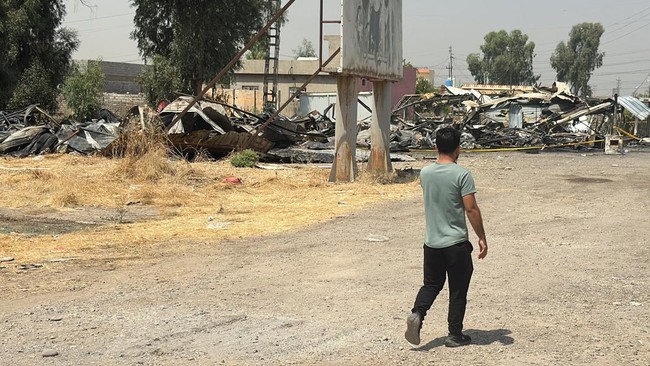 A man walks near damage at a site belonging to Iraq's Popular Mobilization Forces (PMF) following airstrikes that the PMF said were carried out by U.S. and Saudi forces, in Bartella, Nineveh province, Iraq, July 29, 2026. Picture taken with a mobile