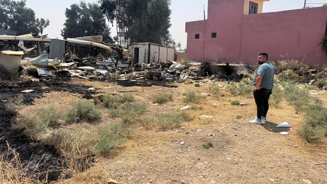 A man looks on near damage at a site belonging to Iraq's Popular Mobilization Forces (PMF) following airstrikes that the PMF said were carried out by U.S. and Saudi forces, in Bartella, Nineveh province, Iraq, July 29, 2026. Picture taken with a mobi