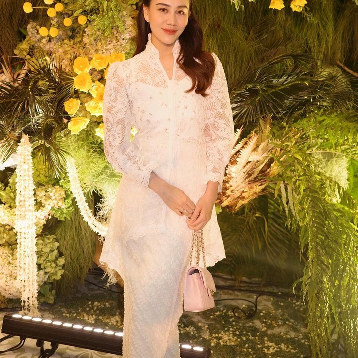 <p>Pilihan kebaya brokat putih kerah shanghai membuat penampilannya terlihat cantik dan elegan. Bisa menjadi inspirasi Bunda untuk menghadiri pernikahan bersama suami. (Foto: Instagram @aaliyah.massaid)</p>