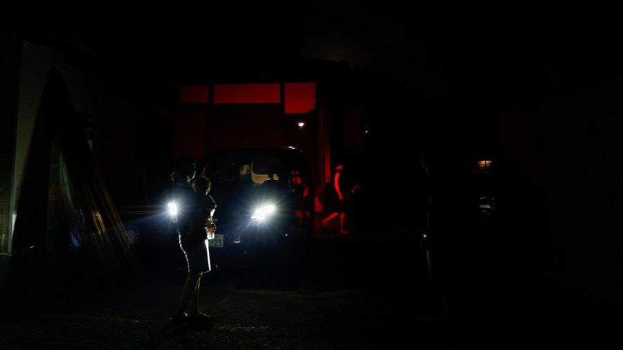 Sebuah family menggunakan lampu dari mobil dan generator pribadi mereka, setelah gempa bumi di Uki, Jepang, 30 Juli 2026. (REUTERS/Kim Kyung-Hoon)