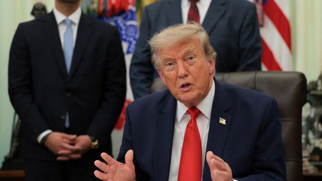 U.S. President Donald Trump speaks as he sits behind an airport model as he makes an announcement about a $22.5 billion renovation of Washington Dulles International Airport with U.S. Secretary of Transportation Sean Duffy (not pictured) in the Oval