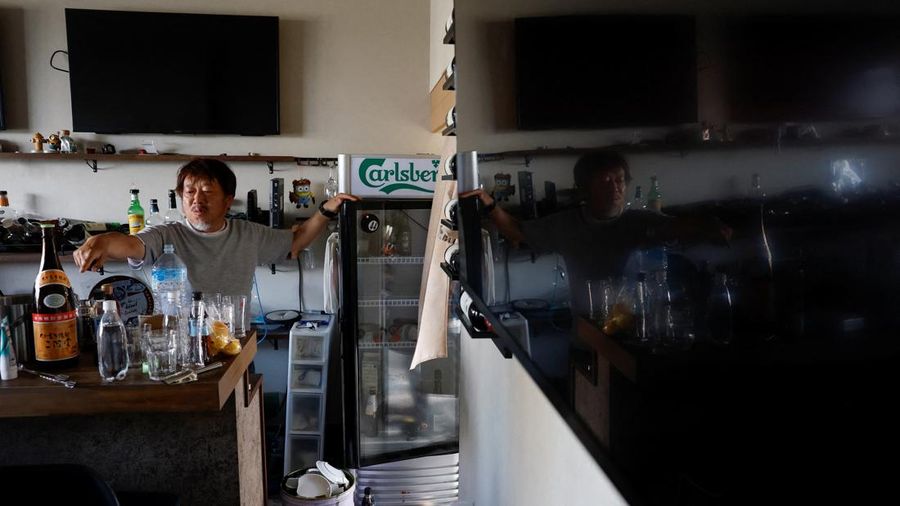 Yusuke Hashimoto, 50 tahun, pemilik Sport Bar 44, membersihkan barang-barang nan rusak dan berceceran di barnya setelah gempa bumi, sementara pemadaman listrik dan air tetap bersambung di Uki, Jepang, 30 Juli 2026.